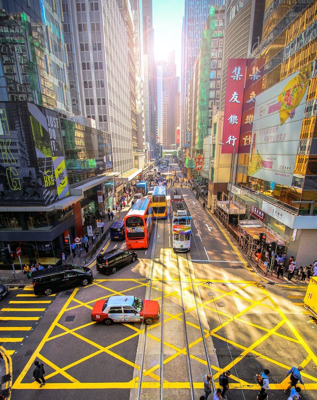 Yellow crossing in busy street in Hong Kong with tram, bus and taxi