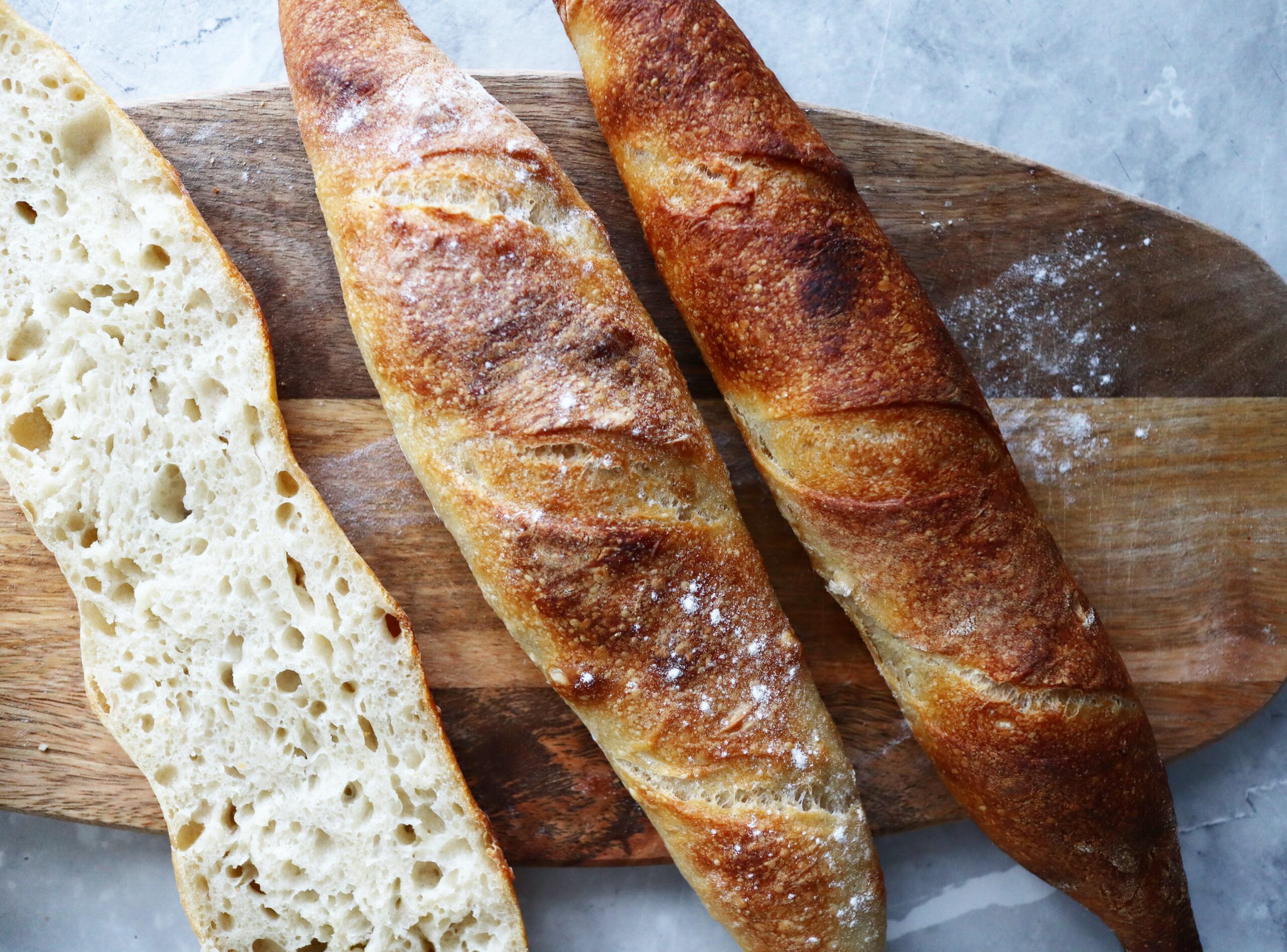 Two french baguettes on a wooden cutting board